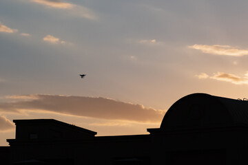 Fototapeta na wymiar Modern drone silhouette on blue sky background.