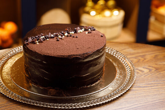 Chocolate cake with nuts and chocolate chips. Close-up with blurred background.