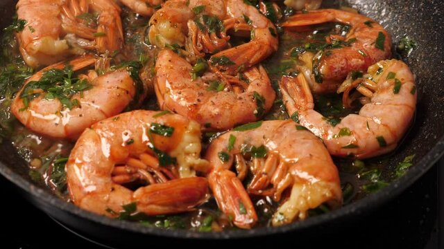 Cooking big shrimps on frying pan. Preporation langoustines. Closeup. Top view