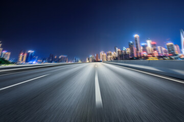 Motion blurred asphalt road and city skyline with modern commercial buildings
