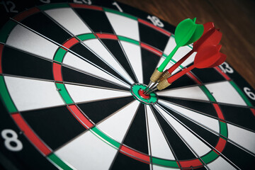 Concept of competition and goal achievement.Achieving goals in business and life.Dartboard with three darts stuck right center of target.
