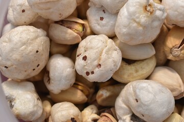 Background made of mixed nuts and raisins. Almond, pistachio and makhanas.Healthy snack and food closeup