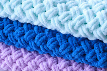 Background, warm, delicate and plush handmade baby blankets in colors of blue, lilac and mint.