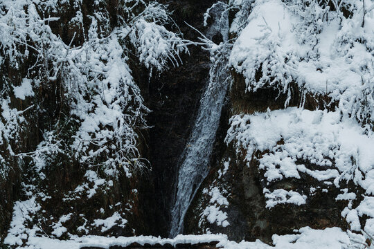 View of the Jana Waterfall during the snowfall at Manali, Himachal Pradesh, India. Waterfall during the winter snow in Manali, Holiday background, Travel Concept. Snowfall in Manali during the winter.
