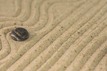 Zen sand garden meditation stone background with copy space. Stones and lines drawing in sand for relaxation. Concept of harmony, balance and meditation, spa, massage, relax