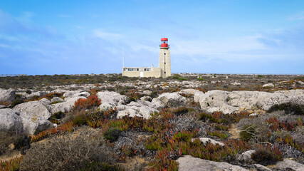 Obraz premium Lighthouse in barren rocky landscape