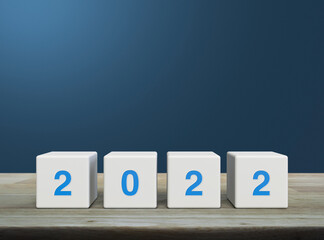 2022 letter on white block cubes on wooden table over light blue gradient background, Happy new year 2022 cover concept
