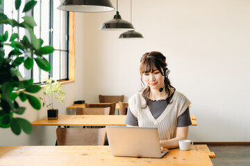 ヘッドセットをつけてパソコンを使う女性
