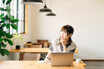 カフェで勉強する女性（考える）
