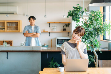 仕事する女性と家事をする男性（笑顔・電話）
