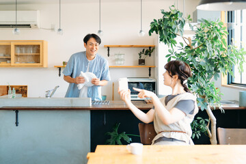 家でくつろぐ仲の良い夫婦（スマホ）  © buritora