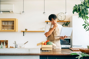 ダンボールに入った野菜と男性（パソコン・困る）
