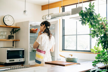 冷蔵庫の中を見る女性
