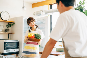 冷蔵庫の前に立つ女性と男性（野菜）
