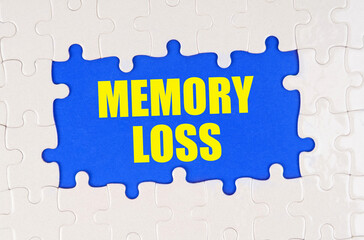 Inside the white puzzles on a blue background it is written - MEMORY LOSS