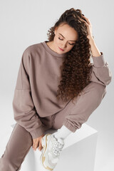 Cropped portrait of a model girl with trendy hairstyle wearing a blanket sweatshirt over white background