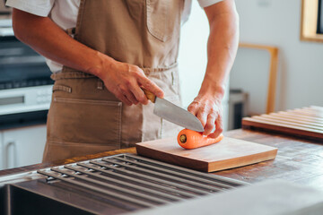 キッチンに立つ男性（野菜を切る）

