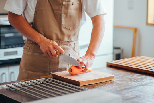 キッチンに立つ男性（野菜を切る）
