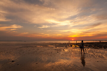 female amateur photographer Taking sunset pictures on the beach