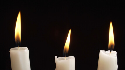 Shooting of burning a three candles on dark background