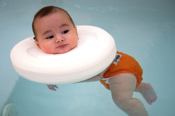 Baby enjoying in the jacuzzi. Spa for babies. Hydrotherapy session for children. Baby swimming