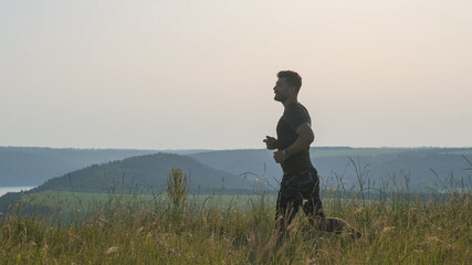 The handsome man jogging on the picturesque background