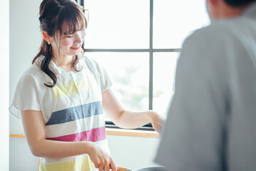 料理をする女性と見ている男性  © buritora