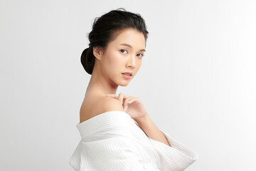 Beautiful young Asian woman wearing bathrobe on white background, Face care, Facial treatment,...