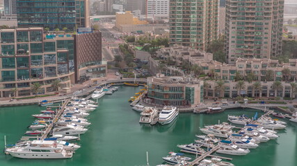 Fototapeta premium Luxury boats and yachts docked in Dubai Marina aerial timelapse.