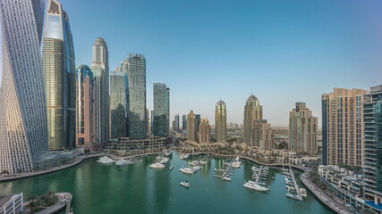 Fototapeta na wymiar Dubai marina tallest skyscrapers and yachts in harbor aerial day to night timelapse.