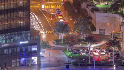 Aerial view of a circle road intersection between skyscrapers in a big city night timelapse.