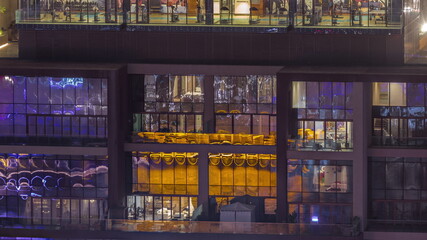 Flat night panorama of multicolor light in windows of multistory buildings aerial timelapse.