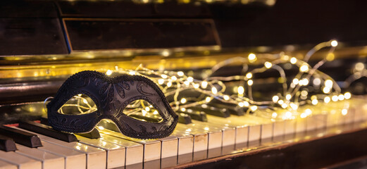 Carnival Piano music, black mask and bokeh lights background.