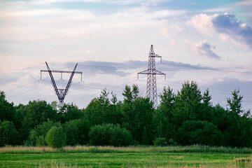 Steel towers of power lines on the background of the forest. Technological concept.