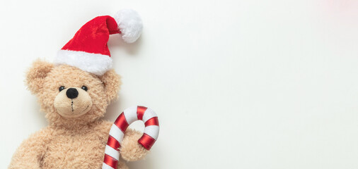 Christmas present. Teddy bear wearing a Santa hat on white background, Holiday greeting card.