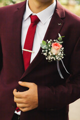 groom in burgundy wedding suit, white shirt and tie