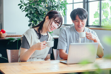 家でパソコンを使う男女
