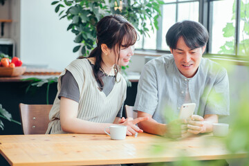 スマホを見る男性と女性（コーヒー）
