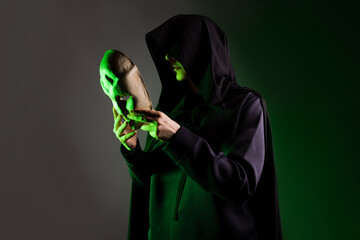 An anonymous villain, a hidden figure in a black cape with a hood. A mystical character with a...