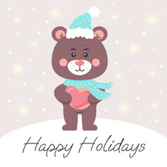 Cute teddy bear in a scarf and hat holding a heart. Happy Holidays lettering. Greeting card.