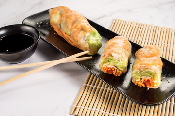 Fototapeta na wymiar Fresh tasty sushi spring rolls with chicken and shrimps. Japanese cuisine