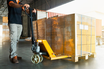 Workers Courier Using Hand Pallet Jack Unloading Package Boxes into Cargo Container. Delivery Shipment Boxes. Trucks Loading at Dock Warehouse. Supply Chain. Warehouse Shipping Transport  Logistics.	