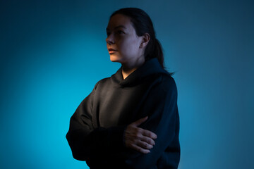 Fototapeta premium Hard light, face in partial shade. Work of thought, concept. The birth of an idea, a cognitive process in the mind. Young woman portrait side view