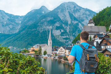 Fototapeta na wymiar man with backpack looking at hallstatt city