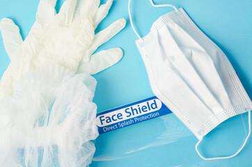 Personal protective equipment : PPE. Disposable face mask, Face shield and Gloves on blue background.