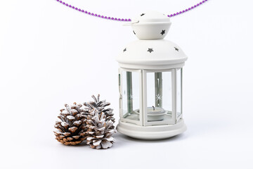 White lantern with candle inside and Christmas decoration on white background. Copy space.