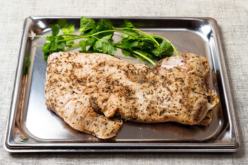 Raw pork belly slice with seasoning on a metal stainless steel tray. Meat industry product with fresh green coriander.