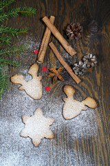 christmas ginger cookies with a traditional set of spices on a dark wooden background