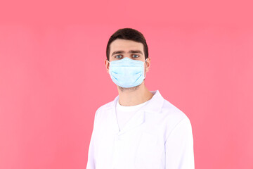 Doctor - intern in mask on pink background