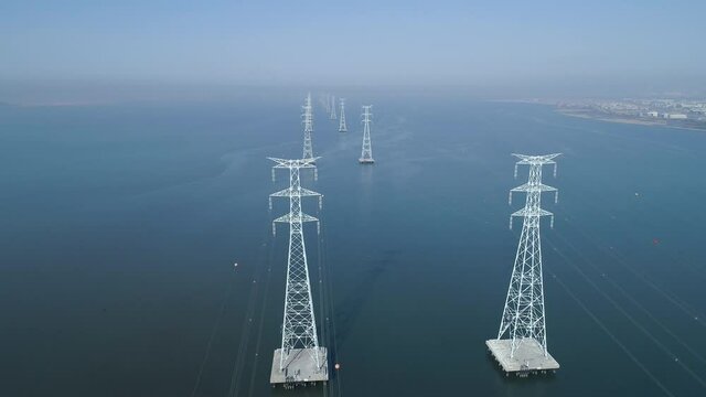Aerial view of electric transmission tower above the sea, high voltage steel pylon, power, electric, energy, industry. 시화호, 철탑, 고압선, 송전탑.	
